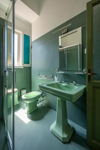 ein grünes Badezimmer mit Waschbecken und Toilette in der Unterkunft Dimora Cavaliere Scioli in Monteroduni