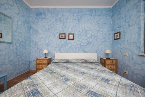 a blue bedroom with a bed and two night stands at Agriturismo La Meria in Semproniano