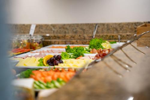 a buffet line with different types of food on plates at Park Hotel Laim in Munich