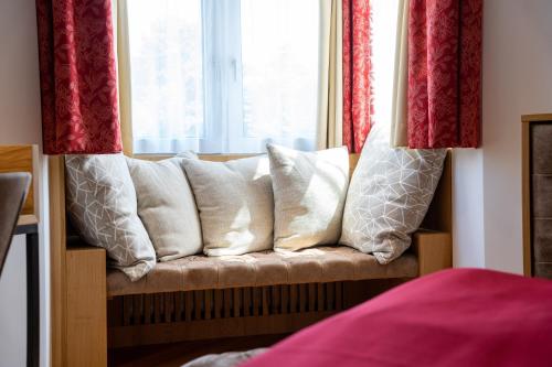 a couch with pillows sitting in front of a window at Park Hotel Laim in Munich
