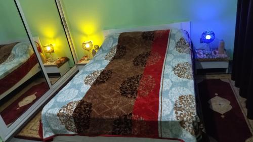 ein Schlafzimmer mit einem Bett mit einer Decke darauf in der Unterkunft 2 minutes a l'aéroport in Marrakesch