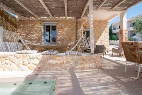 a patio with a hammock and a swimming pool at TERRA E SOLE spa suite Aegina in Souvala
