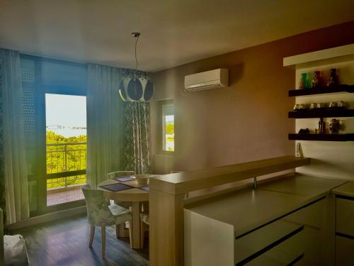 eine Küche mit einem Waschbecken, einem Tisch und einem Fenster in der Unterkunft Vista Sul Mare II in Burgas City