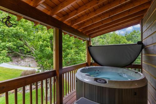 a jacuzzi tub on the deck of a tree house at Eagle Ridge Creek in Banner Elk