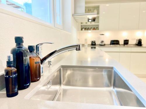 a kitchen sink with two bottles of soap at • Boutique Villa 26 • in Gambarogno in Gambarogno