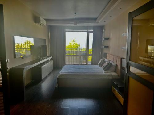 ein Schlafzimmer mit einem Bett und einem großen Fenster in der Unterkunft Vista Sul Mare II in Burgas City
