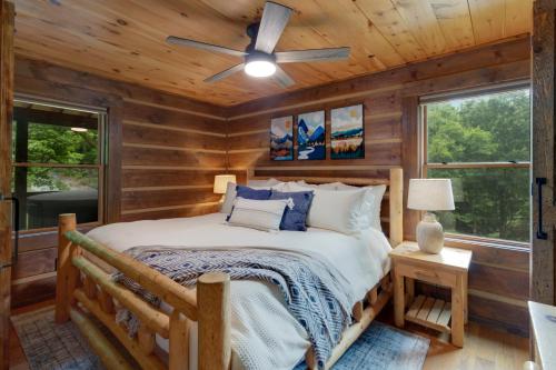 una camera da letto in stile baita di tronchi con letto e ventilatore a soffitto di Eagle Ridge Creek a Banner Elk