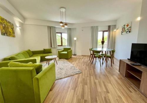 un soggiorno con divano verde e tavolo di Domini LakeView Apartment a Mavrovo