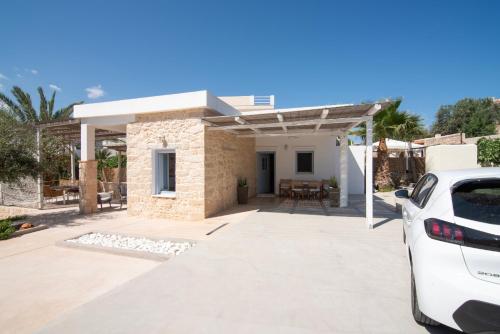 a white car parked in front of a house at TERRA E SOLE spa suite Aegina in Souvala