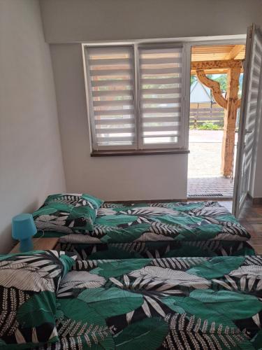 two unmade beds in a room with a window at Noclegi u Wandy in Ropienka