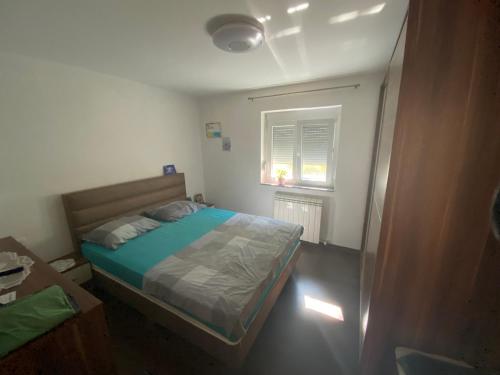 a small bedroom with a bed and a window at Apartma Mira in Zgornje Škofije