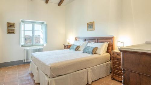 um quarto com uma cama grande e uma janela em Il Colle Di Donna Ilaria 16, Emma Villas em Buonconvento