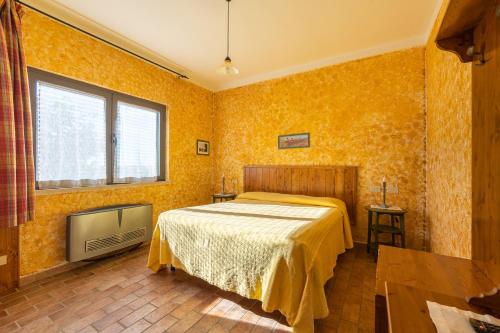 a bedroom with a bed with yellow wallpaper at Agriturismo La Meria in Semproniano