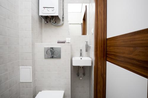 a small bathroom with a sink and a toilet at Studio Świętojańska in Gdynia