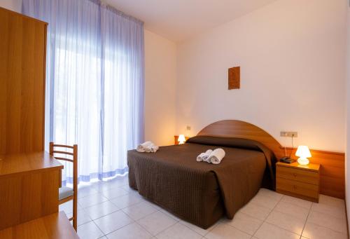 una camera da letto con un letto e due asciugamani di Centro Vacanze Domus M.G. a San Benedetto del Tronto