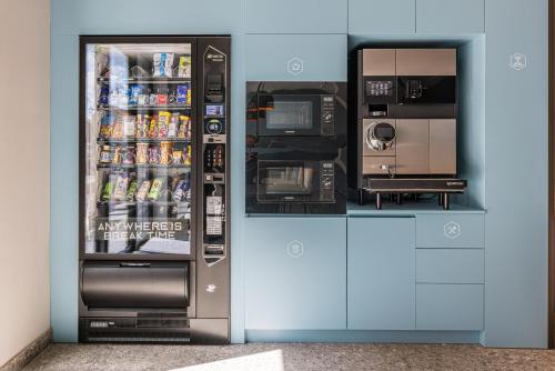 a refrigerator with food and drinks inside of it at YUMA Apartments Leipzig Berliner Straße in Leipzig