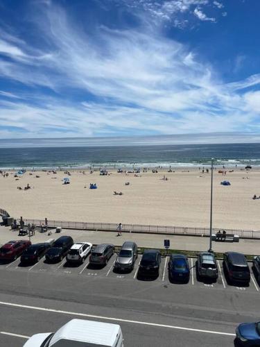 um parque de estacionamento ao lado de uma praia com carros estacionados em Hampton Beach OCEAN FRONT Condo at the Surf em Hampton