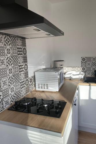 une cuisine avec une cuisinière et un micro-ondes dans l'établissement Le Gîte 55, à Paimpol