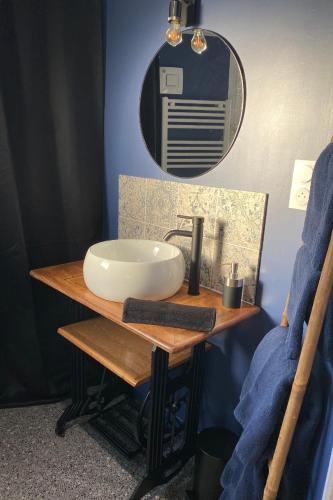 une salle de bain avec un lavabo et un miroir dans l'établissement Le Gîte 55, à Paimpol