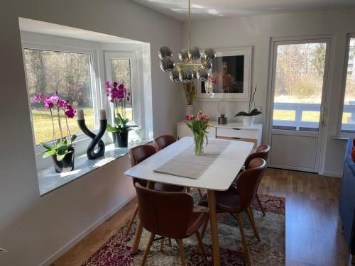 une salle à manger avec une table et des chaises blanches dans l'établissement Hus nära bad ,golf ,nöjen , gym och natur., à Askim