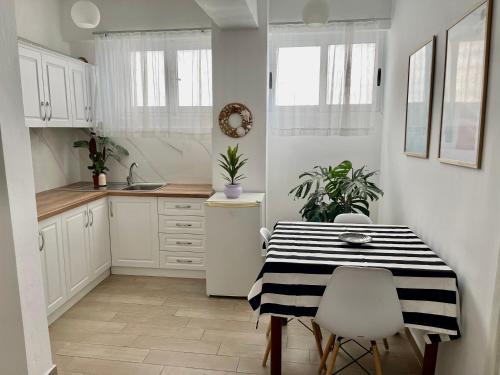 a kitchen with a black and white table and chairs at Lola’s Apartment in Durrës