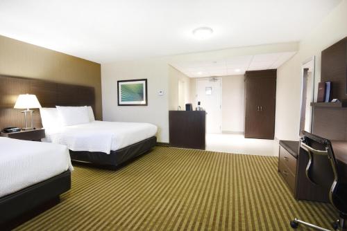 a hotel room with two beds and a flat screen tv at Victoria Inn Hotel and Convention Center Winnipeg in Winnipeg