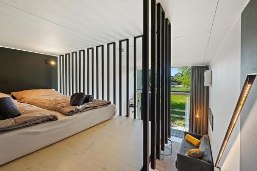 sypialnia z łóżkiem i dużym oknem w obiekcie KODA LOFT EXTENDED - Urlaub im Tiny House Bodensee w mieście Lauterach