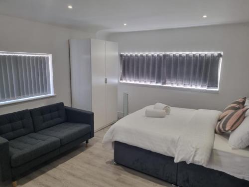 a bedroom with a bed and a couch at The Coppice-Private Studio Guest Suite With Private Entrance in Watford