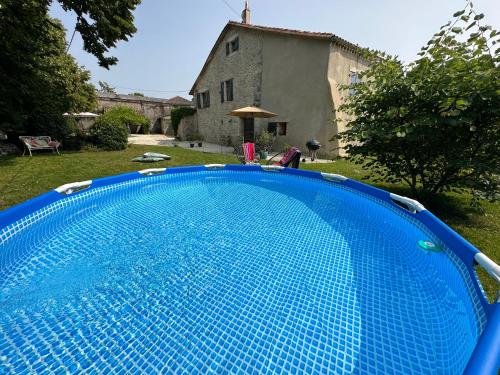 une grande piscine bleue devant une maison dans l'établissement Bed & Breakfast Elisabeth, à Saint-Matré