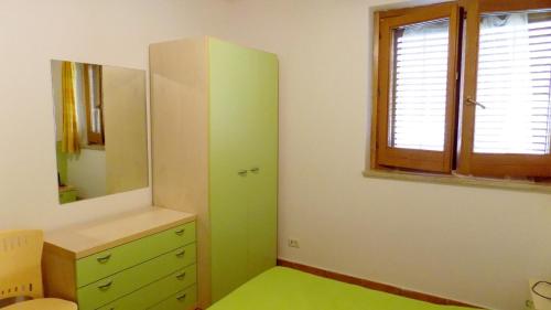 a bathroom with a green cabinet and a mirror at Taormina al mare Villetta in Mazzeo