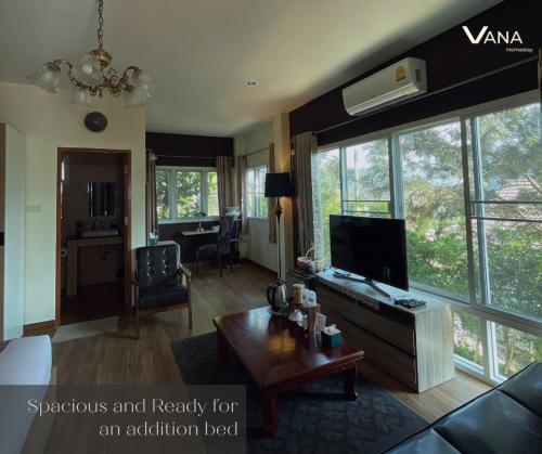 VANA Homestay في Ban Tai: غرفة معيشة مع أريكة وتلفزيون وطاولة