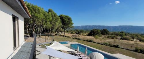 a villa with a swimming pool and views of the mountains at Les pins du Luberon in Coustellet