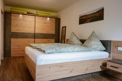 a bedroom with a bed with a wooden headboard at Ferienwohnung Bergzeit in Oy-Mittelberg