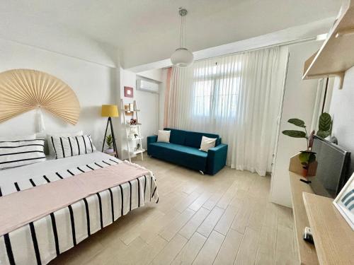 a bedroom with a bed and a blue couch at Lola’s Apartment in Durrës