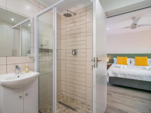 a bathroom with a shower and a sink and a bed at Stunning Villa with pool and views of Knysna in Knysna