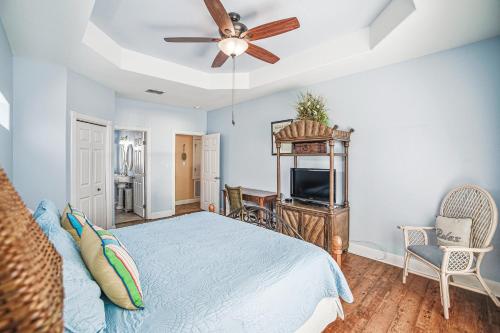 a bedroom with a bed and a ceiling fan at Villa Laguna! STEPS to the pool & lagoon views, with boardwalk to beach in Port Aransas