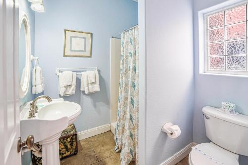 a white bathroom with a sink and a toilet at Villa Laguna! STEPS to the pool & lagoon views, with boardwalk to beach in Port Aransas
