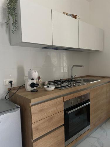 a kitchen with white cabinets and a stove top oven at B&B Le Rocce in Castel San Giorgio
