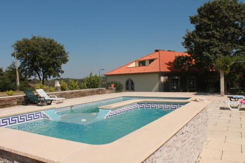 uma piscina em frente a uma casa em Quinta do Adil em Macedo de Cavaleiros