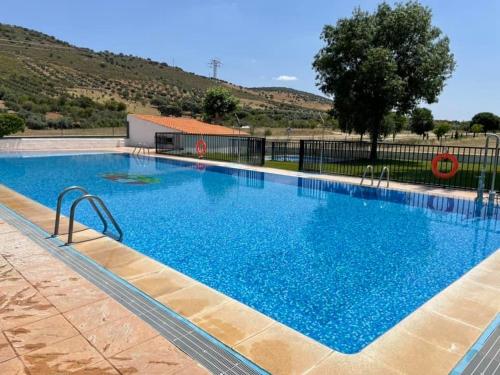 a large swimming pool with blue water at Casa Rural El Corralillo del Abuelo 