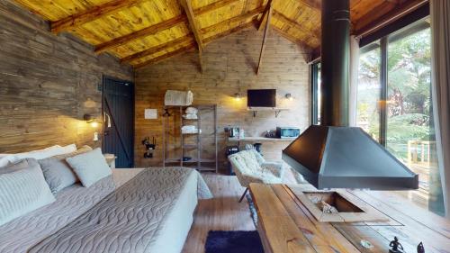 a bedroom with a bed and a large window at Cisne Negro Villarejo in Urubici