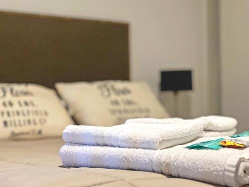einen Haufen Handtücher auf einem Bett mit Kissen in der Unterkunft Parque Pueyrredon IV in Mendoza