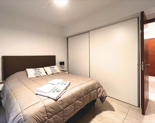 Schlafzimmer mit einem Bett mit Glasschiebetür in der Unterkunft Parque Pueyrredon IV in Mendoza