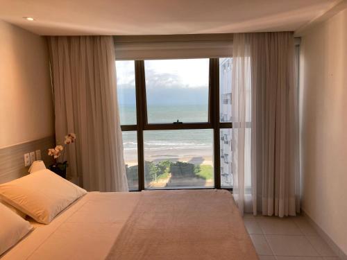 a bedroom with a large window with a view of the ocean at BCE Home Stay in Recife