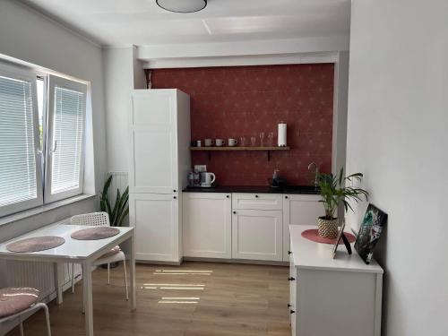 a kitchen with a table and a white refrigerator at Chcę tu zostać Apartamenty Gdynia in Gdynia