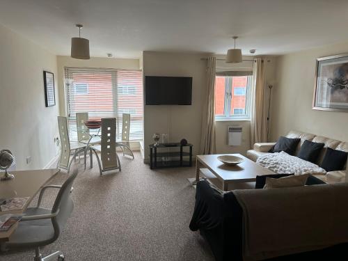 a living room with a couch and a table at Gunwharf Quays Harbour Apartments in Portsmouth