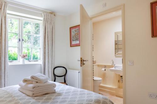 a bedroom with a bed with towels on it at Thyme Cottage in Eastdean