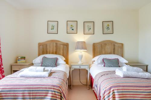 イースト・ディーンにあるThyme Cottageのベッド2台が隣同士に設置された部屋です。