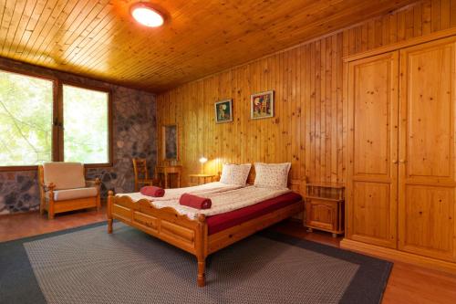 a bedroom with a bed in a room with wooden walls at Eco Hotel Imenieto in Emen