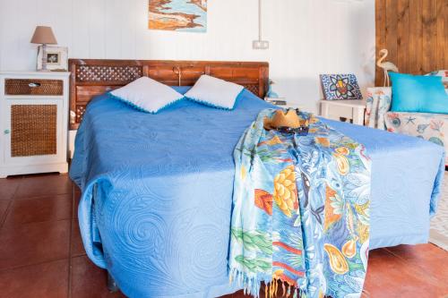 a bed with a blue comforter in a room at Cabin in front of idyllic majanicho beach in Majanicho